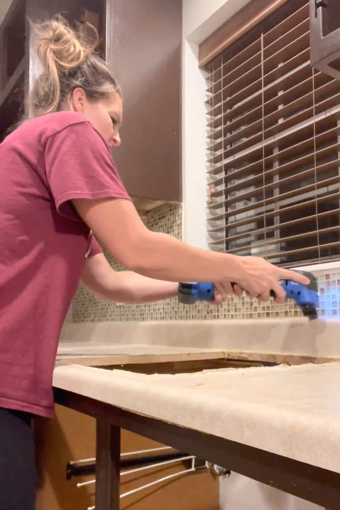 Using a multi-tool to remove a kitchen countertop.